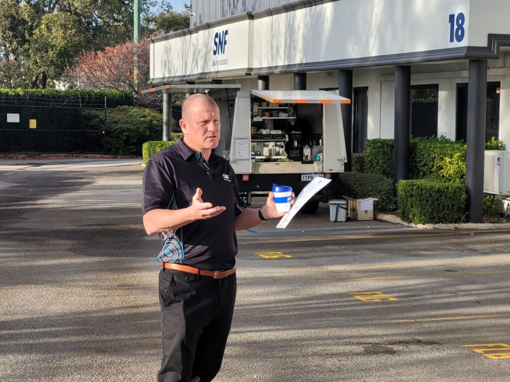 SNF Mining representative speaking outside the SNF Technical Center in Perth, Australia, during an on-site professional briefing.