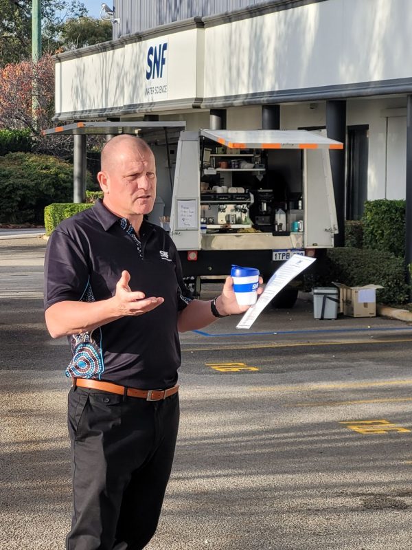 SNF Mining representative speaking outside the SNF Technical Center in Perth, Australia, during an on-site professional briefing.