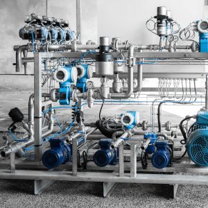 Integrated mining engineering system with pumps, piping, and dosing equipment installed in an industrial processing plant.