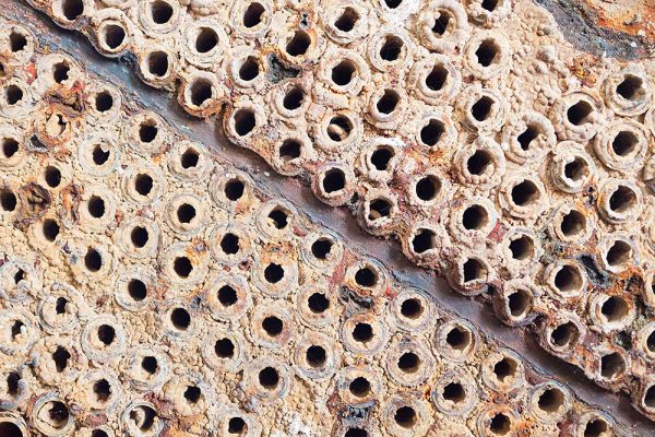 Mineral scale deposits on industrial surface in mining process water system.