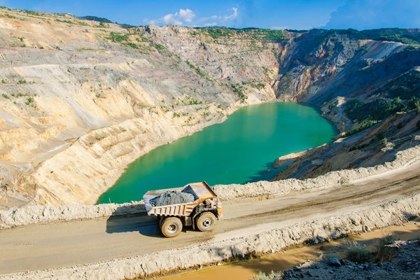 Open-pit mine with process water pond used for thickening and dewatering operations.