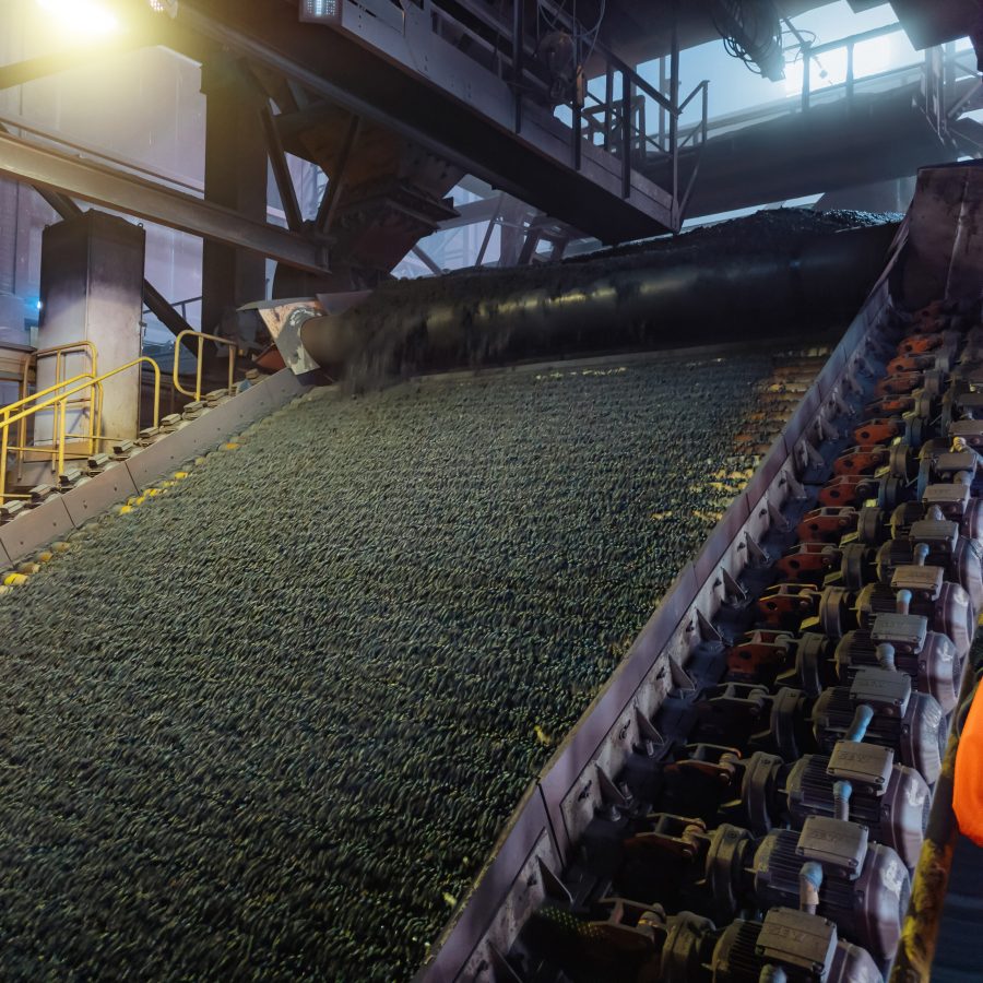 Iron ore pellet conveyor transporting agglomerated pellets to blast furnace feed system